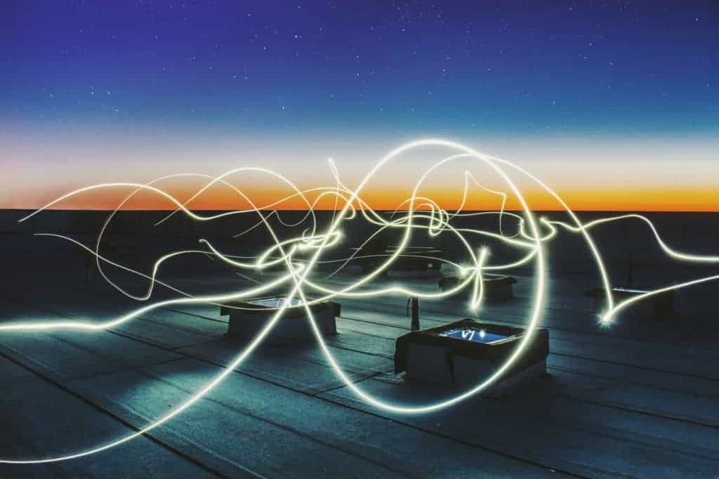 Light Painting auf den Dächern der Stadt vor dem Nachthimmel